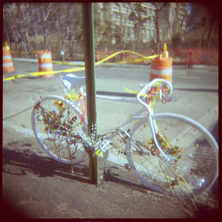 White bicycle locked to a street sign