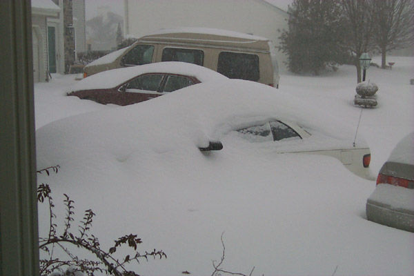 Snow drifting over Laura's car, practically covering it