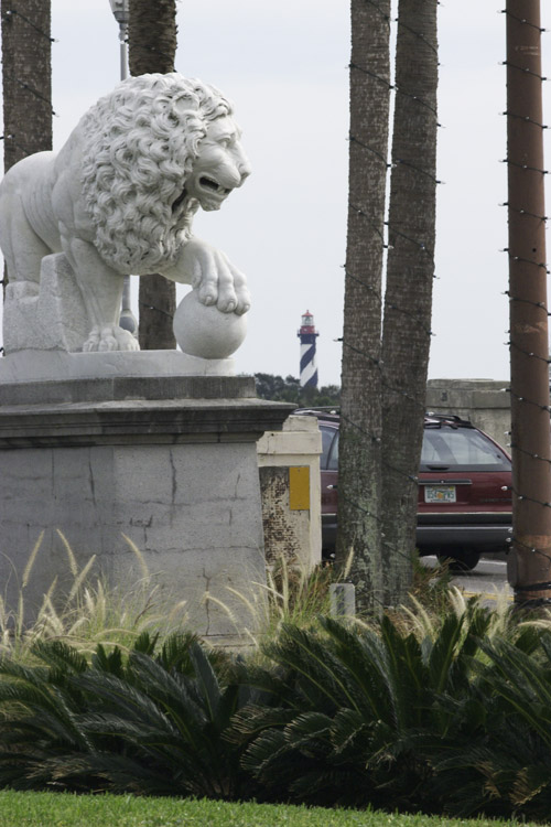 One of the lions from the Bridge of Lions, with St. Augustine Lighthouse in the background